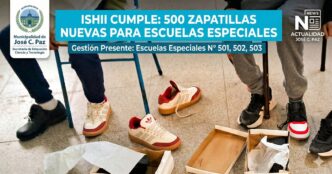 Niños en edad escolar en José C. Paz con discapacidad se prueban con alegría sus nuevas zapatillas blancas con detalles rojos y beige, parte de una entrega municipal de 500 pares a escuelas especiales. Una caja de zapatos abierta en el suelo.