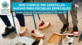 Niños en edad escolar en José C. Paz con discapacidad se prueban con alegría sus nuevas zapatillas blancas con detalles rojos y beige, parte de una entrega municipal de 500 pares a escuelas especiales. Una caja de zapatos abierta en el suelo.